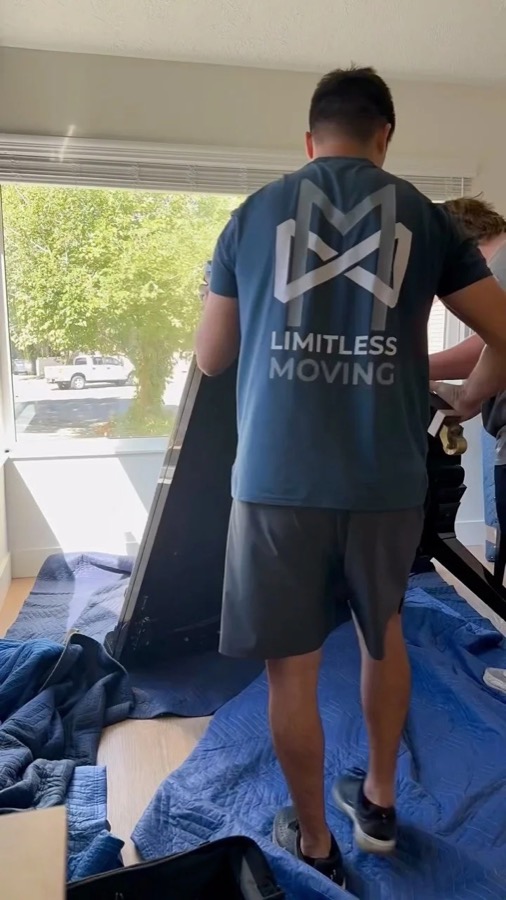 Mover laying protective pads over furniture