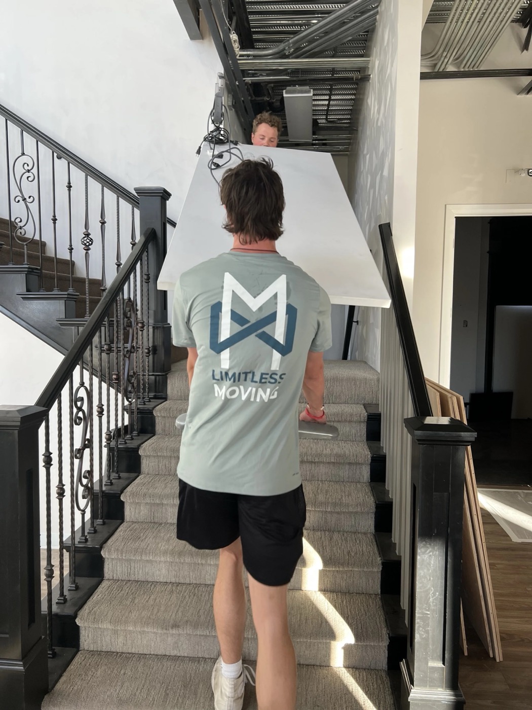 Limitless mover carrying a large item down a staircase
