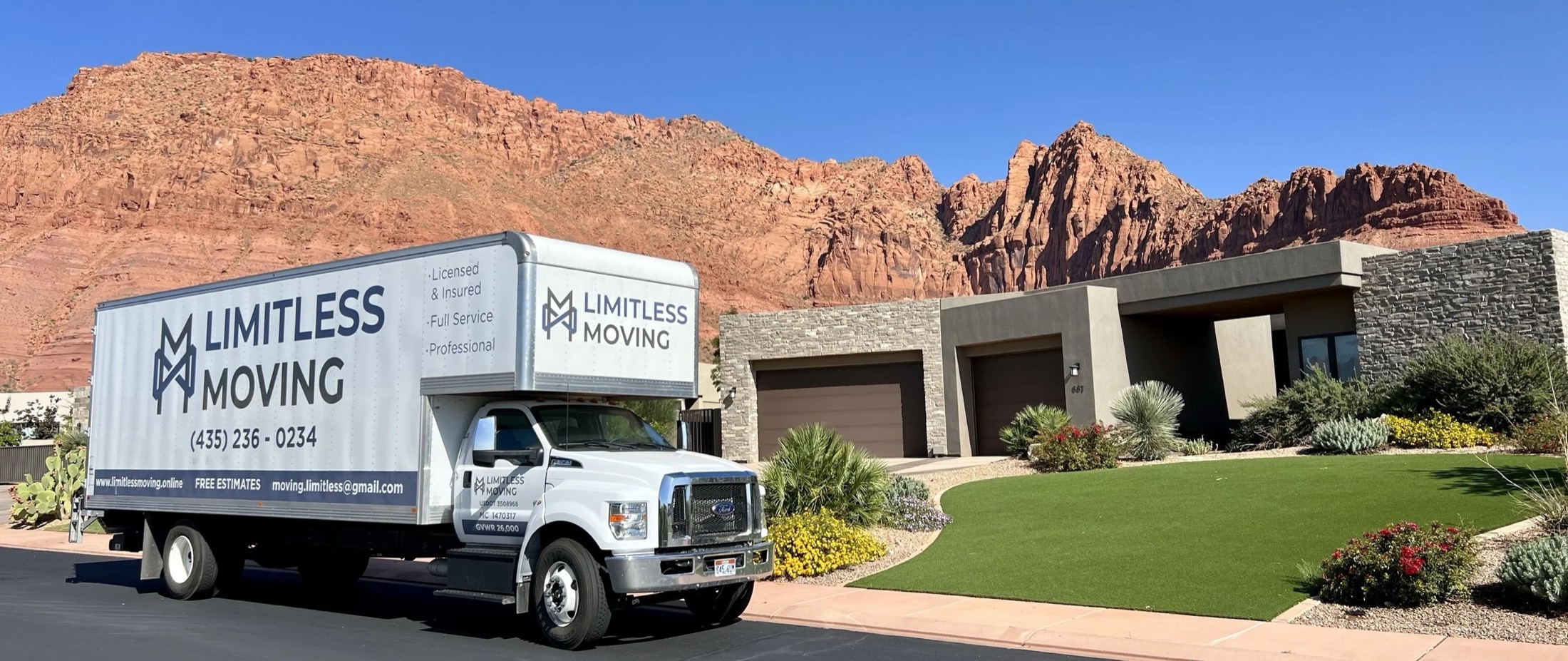 Limitless Moving box truck parked outside a home below the red rock cliffs of St. George