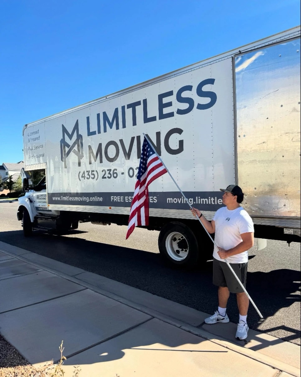 Limitless Moving crew member holding an American flag beside the truck