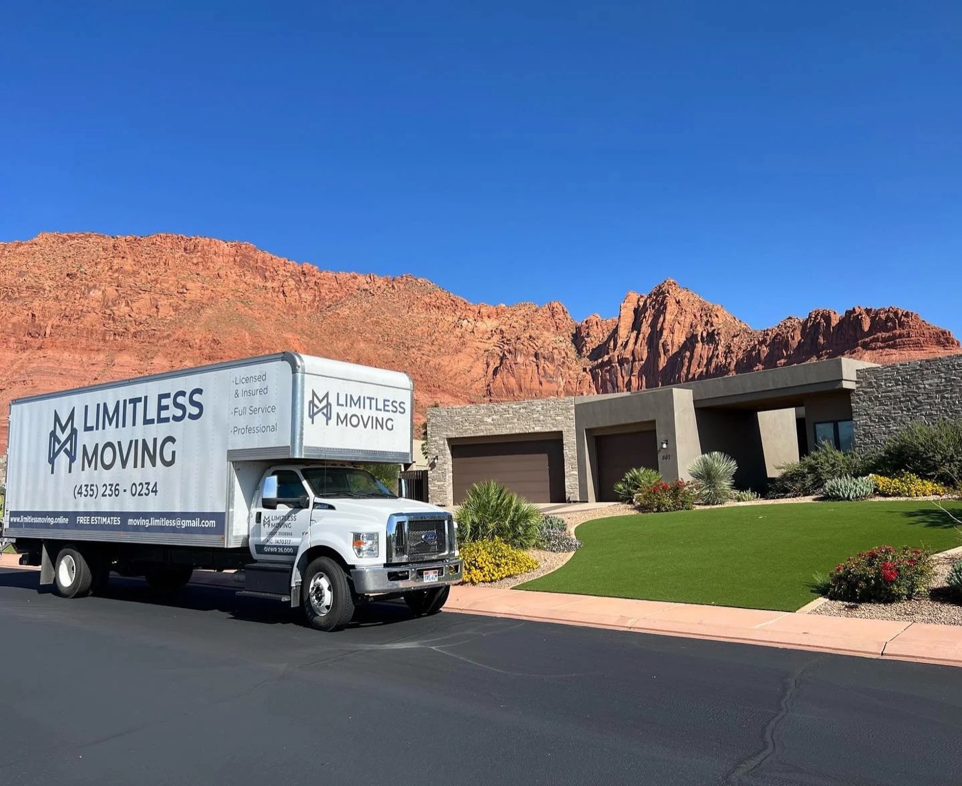 Limitless Moving truck parked on a residential street below red rock cliffs